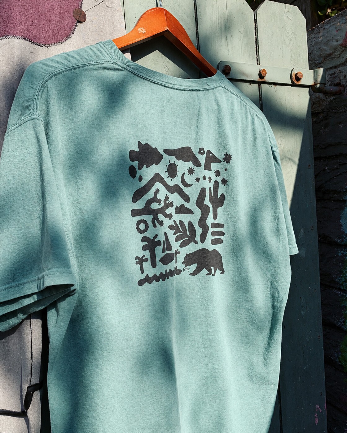 Mint tee with outdoor illustration on the back
