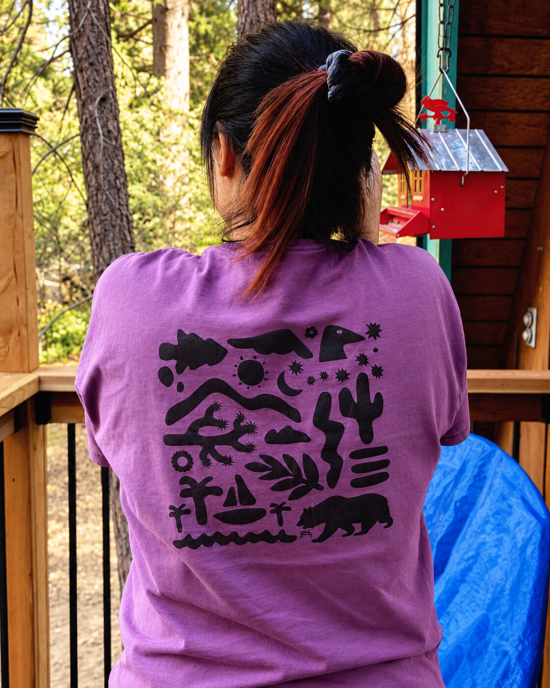 Purple graphic tee on the porch