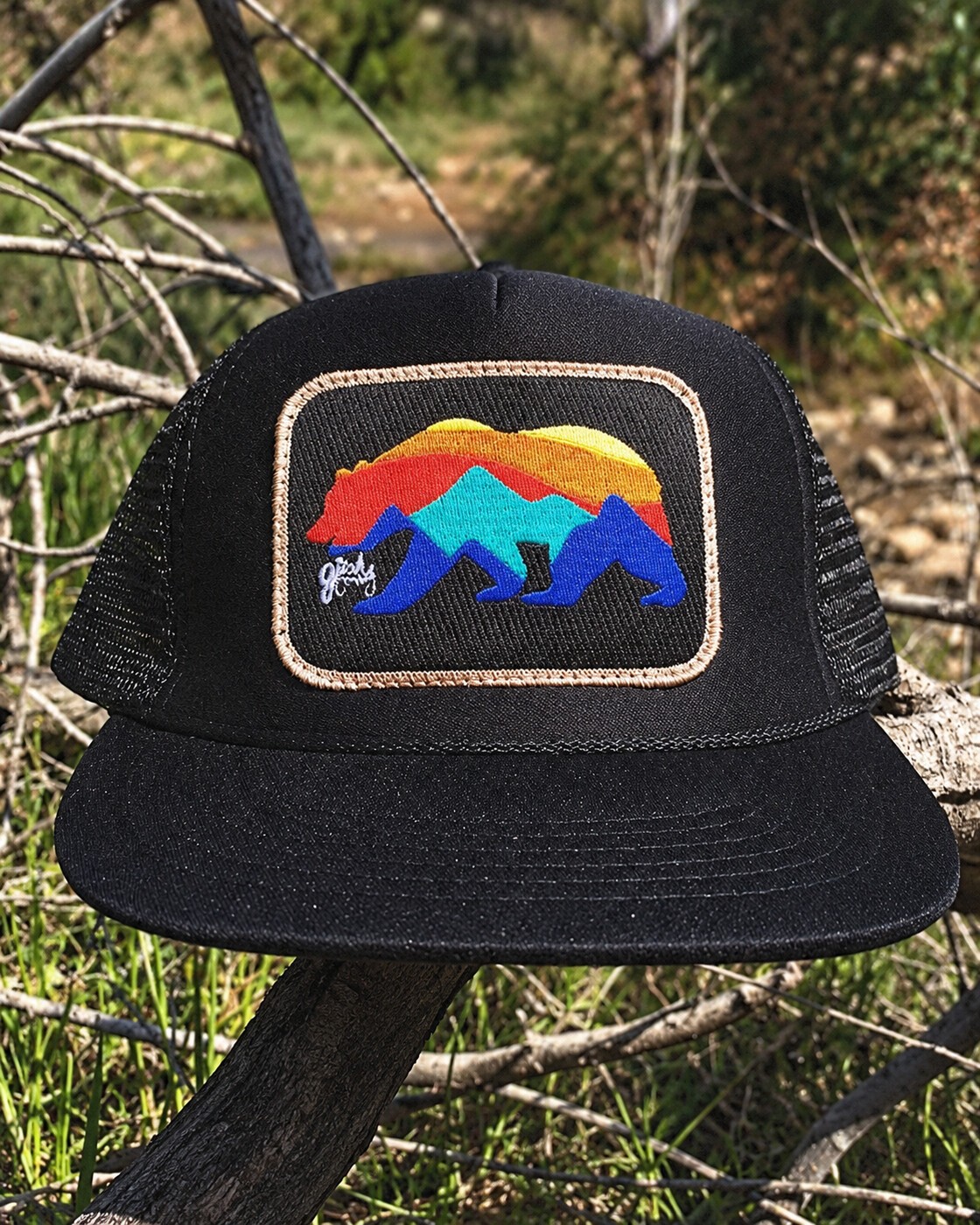 Bear patch hat resting among branches