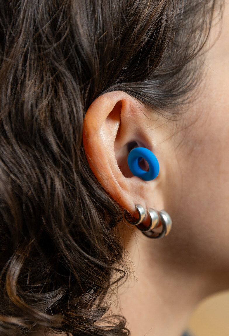 Blue earplug being worn