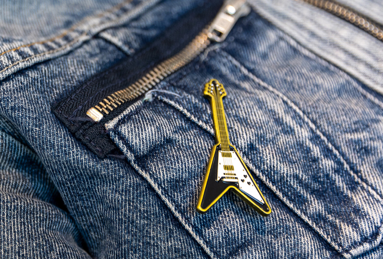 Guitar pin on a denim jacket
